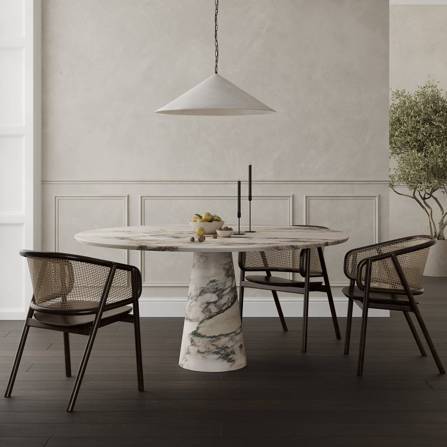 ROMA, the round dining table in Calacatta Monet marble with a tapered pedestal base by Collection Noir. 